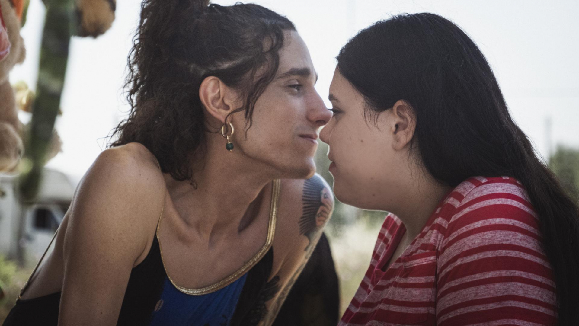 A still from Swing Ride. It shows the two main characters, a trans woman and a young fat girl, with their faces close to each other.